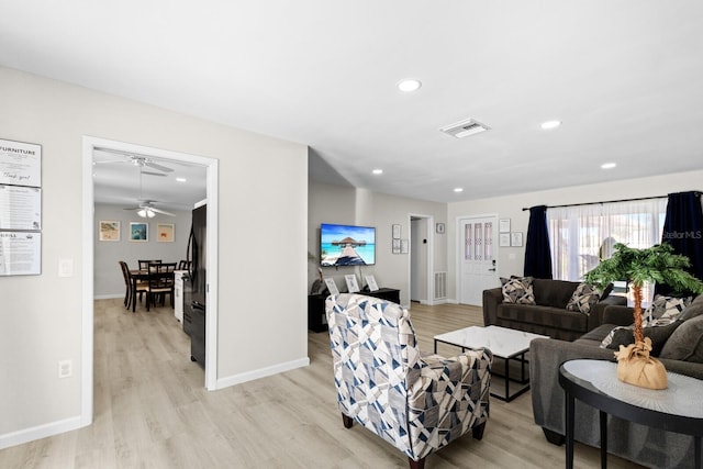 living room featuring light wood-type flooring and ceiling fan