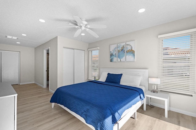 bedroom featuring a textured ceiling, light hardwood / wood-style floors, and ceiling fan