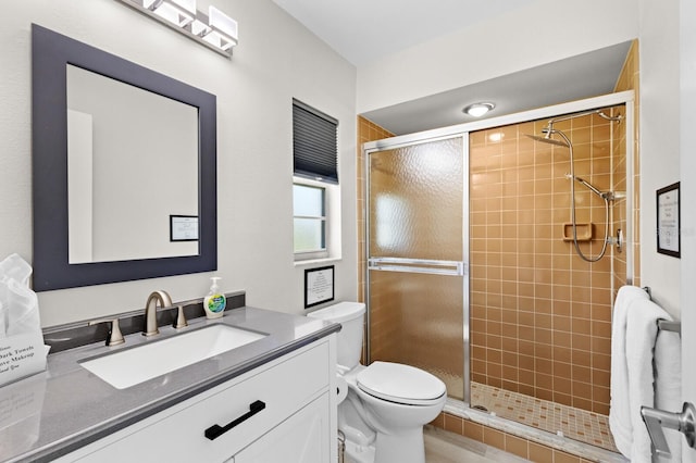 bathroom featuring vanity, toilet, and a shower with door