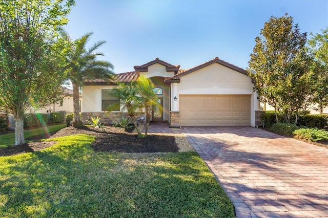 mediterranean / spanish-style house with a garage and a front lawn