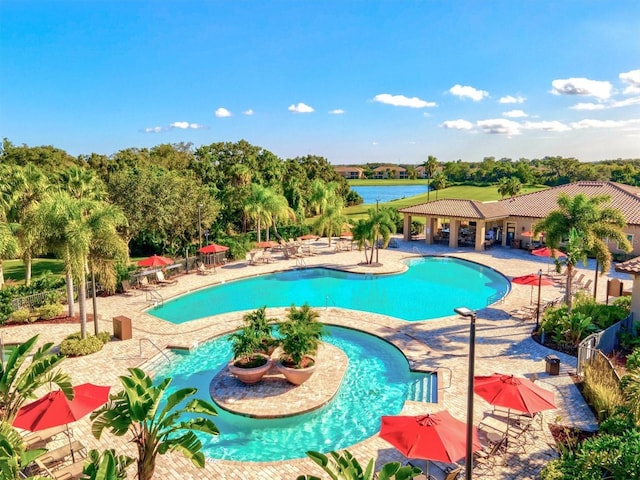 view of pool featuring a water view and a patio