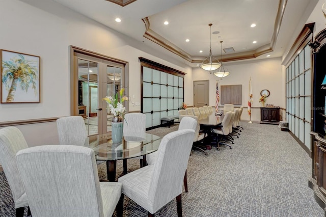 carpeted dining area with french doors and a tray ceiling