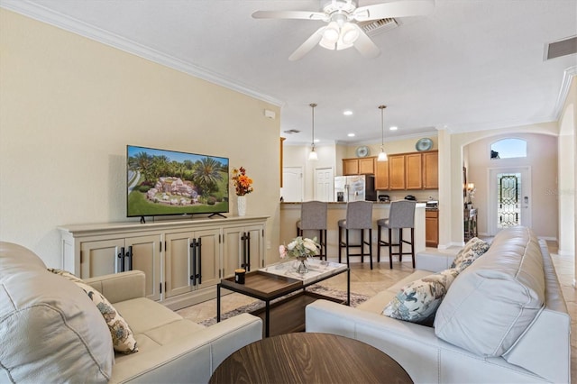 tiled living room featuring ceiling fan and crown molding