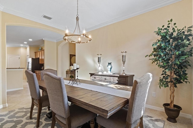 tiled dining space featuring an inviting chandelier and ornamental molding