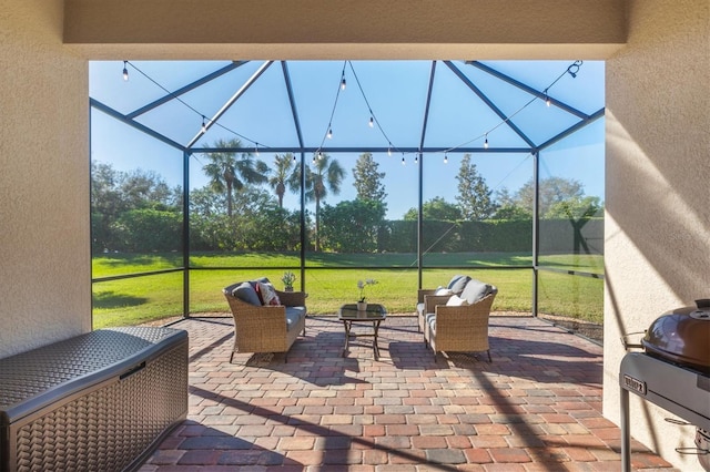 view of patio with outdoor lounge area, glass enclosure, and grilling area