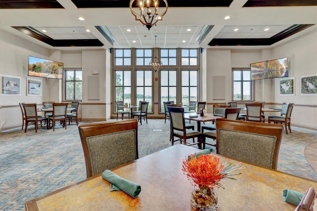 carpeted dining area featuring a high ceiling, ornamental molding, a chandelier, and a healthy amount of sunlight