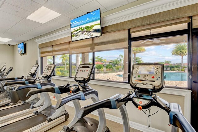 exercise room featuring a paneled ceiling and plenty of natural light