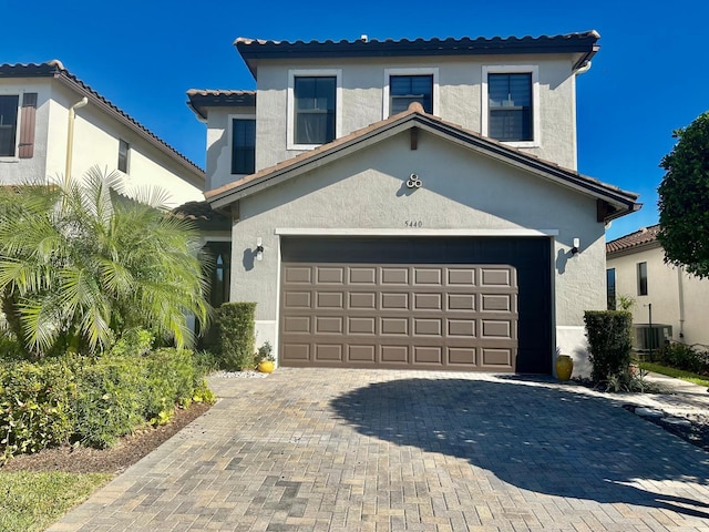 mediterranean / spanish home featuring cooling unit and a garage