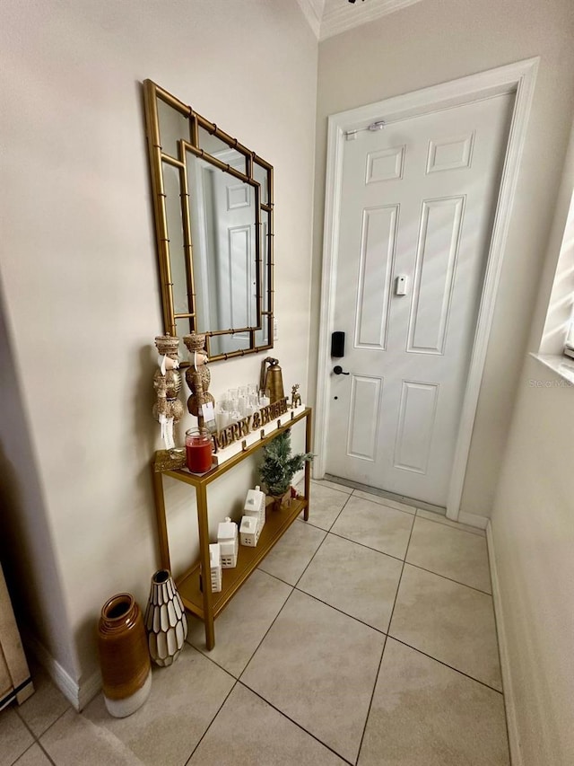 doorway to outside with light tile patterned floors and ornamental molding