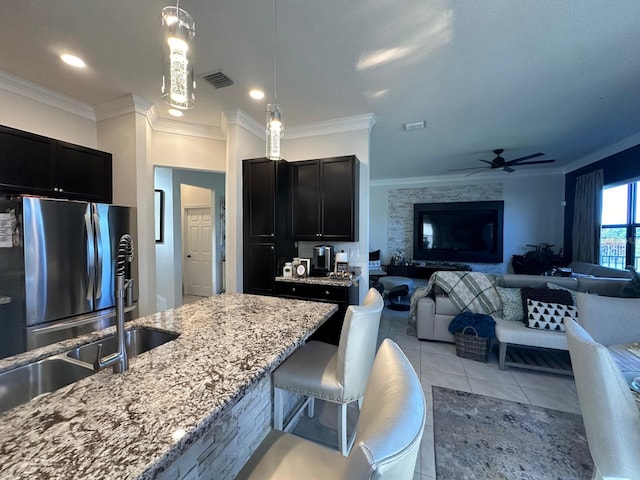 kitchen with light tile patterned floors, stainless steel refrigerator, ceiling fan, and crown molding