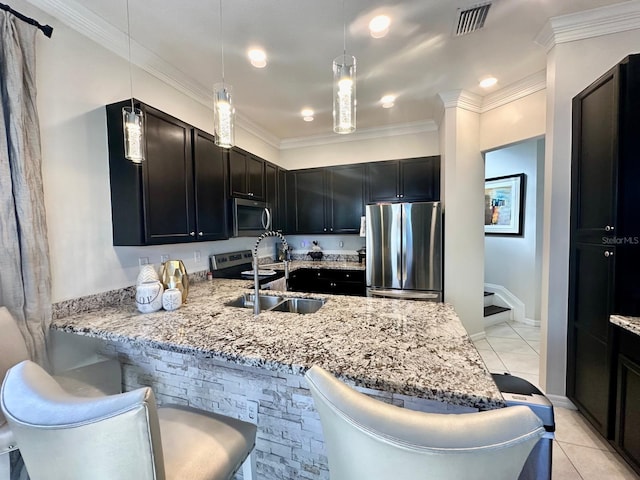 kitchen with kitchen peninsula, appliances with stainless steel finishes, crown molding, pendant lighting, and light tile patterned flooring