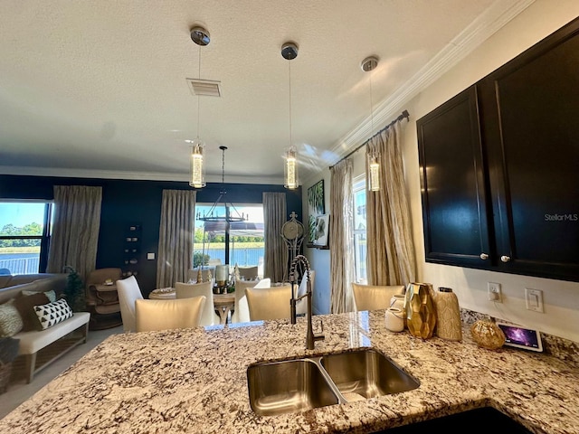 kitchen with a wealth of natural light, sink, a water view, and crown molding