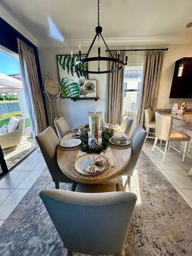 dining room featuring ornamental molding, plenty of natural light, a notable chandelier, and light tile patterned flooring