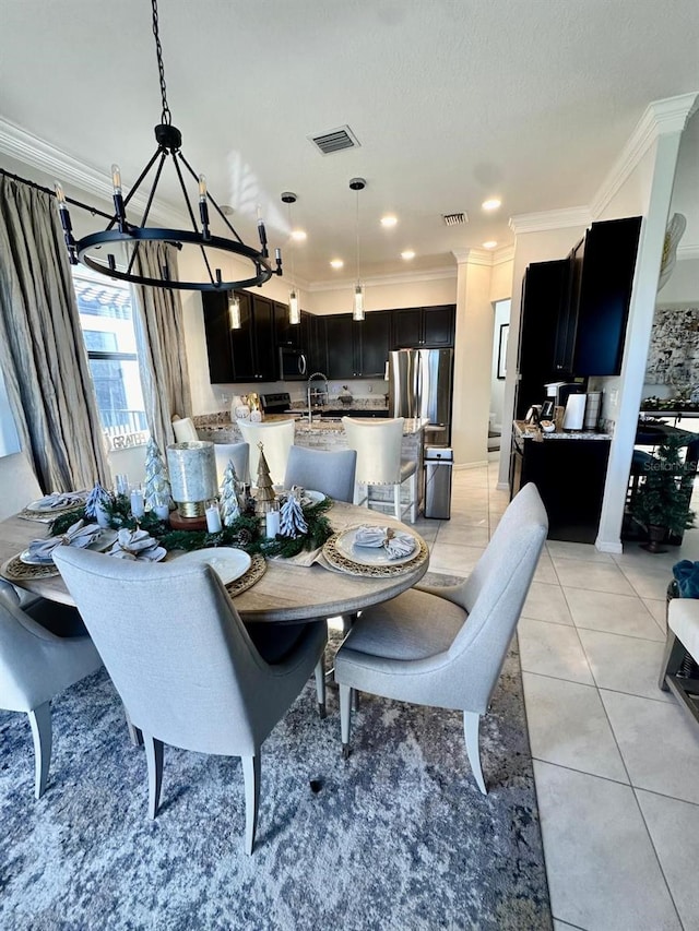 dining space featuring a chandelier, light tile patterned floors, ornamental molding, and sink