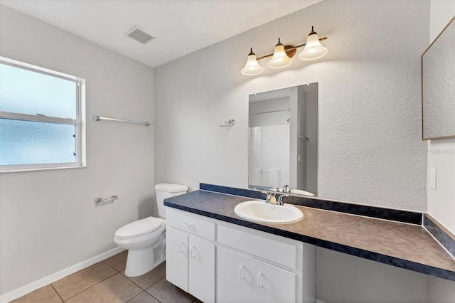 bathroom with tile patterned floors, walk in shower, vanity, and toilet