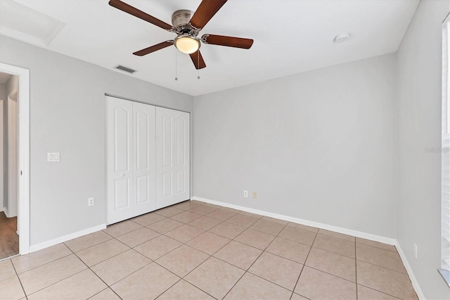 unfurnished bedroom with ceiling fan, light tile patterned flooring, and a closet