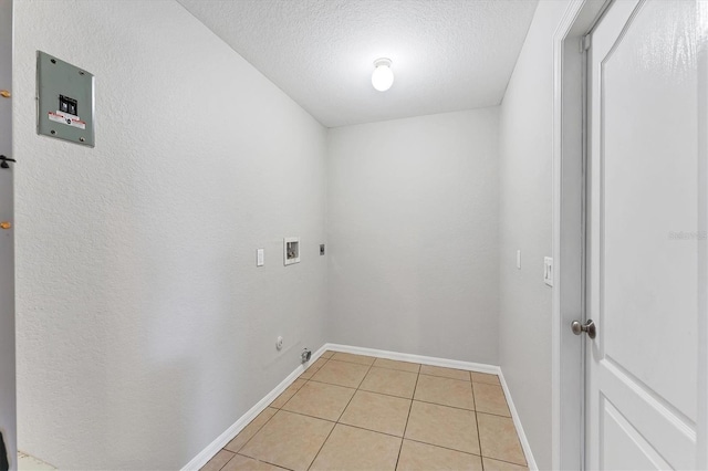 laundry room with washer hookup, hookup for an electric dryer, gas dryer hookup, a textured ceiling, and light tile patterned floors