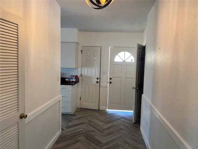 foyer entrance with dark parquet flooring