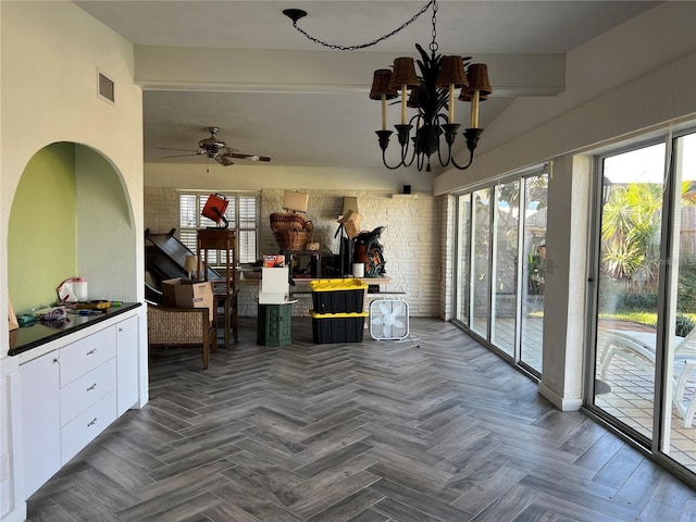 interior space featuring ceiling fan with notable chandelier and dark parquet floors