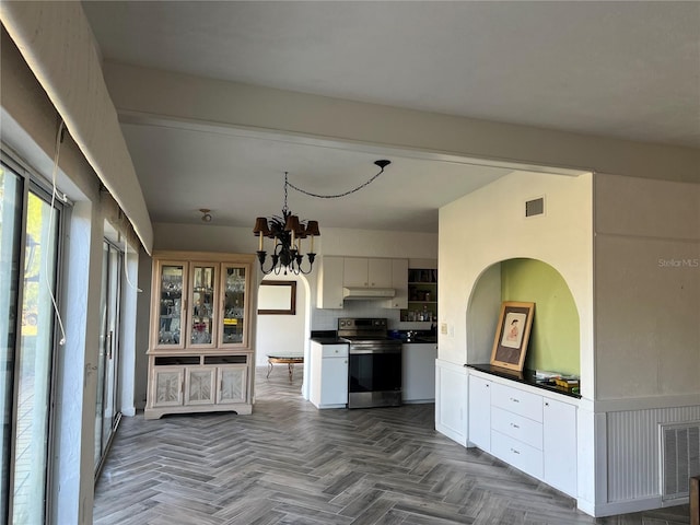 kitchen with white cabinets, parquet floors, a notable chandelier, and electric stove