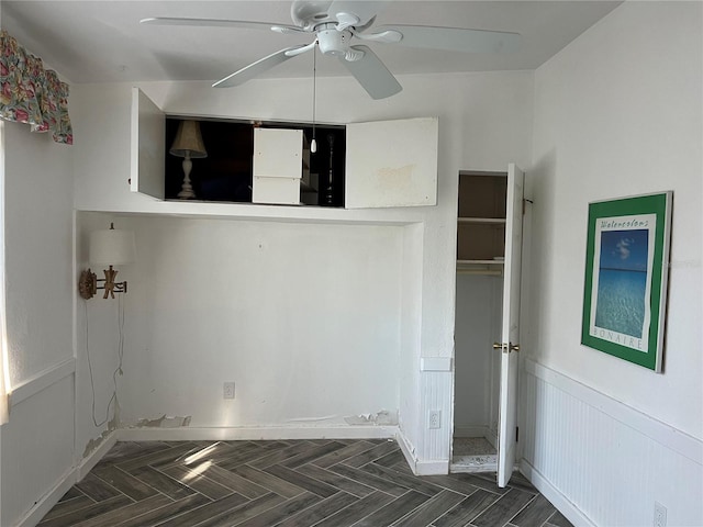 interior space with ceiling fan and dark parquet flooring