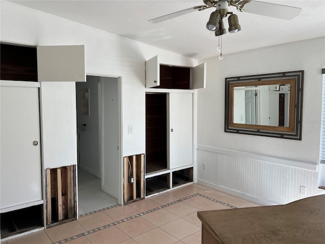 unfurnished bedroom featuring light tile patterned floors, a closet, and ceiling fan