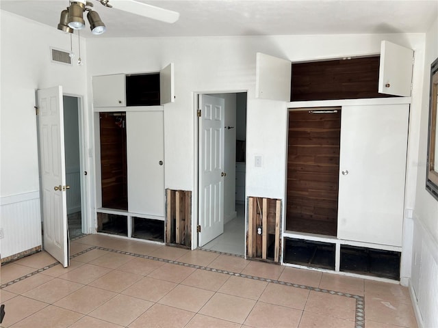 unfurnished bedroom featuring ceiling fan, a closet, light tile patterned flooring, and vaulted ceiling