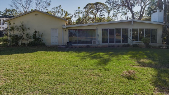 back of house with a yard and a sunroom