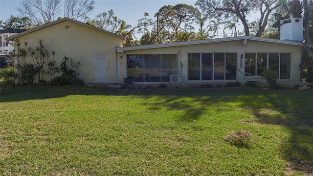 703 32nd Street Ct E, Bradenton, FL 34208 - rear view of property featuring a yard, a chimney, stucco siding, and a sunroom