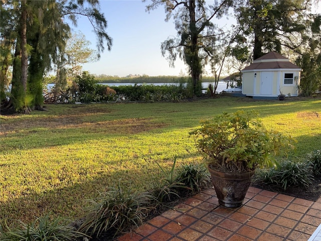 view of yard featuring a water view and a storage unit