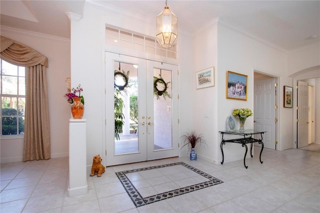 entrance foyer with french doors, ornamental molding, and a healthy amount of sunlight