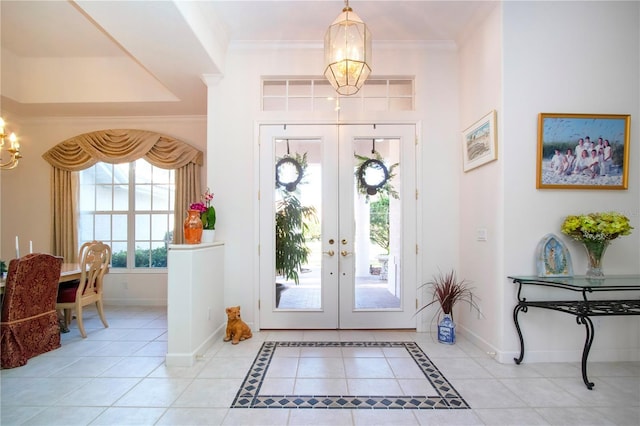 tiled entryway featuring a chandelier, french doors, and crown molding