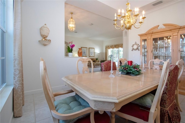 dining area with a chandelier, light tile patterned floors, and ornamental molding