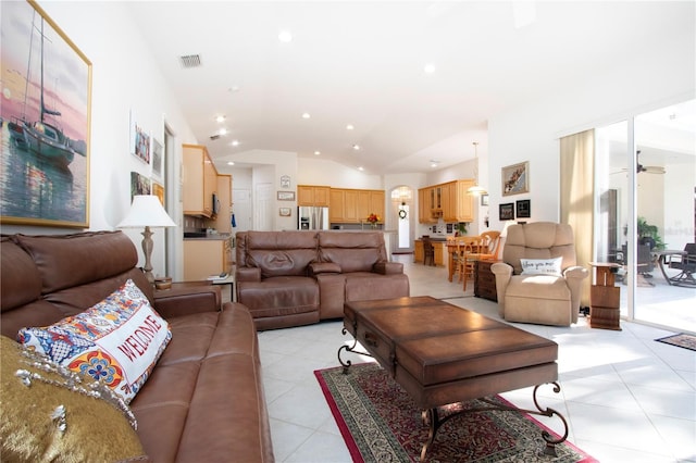 living room with ceiling fan, light tile patterned floors, and lofted ceiling