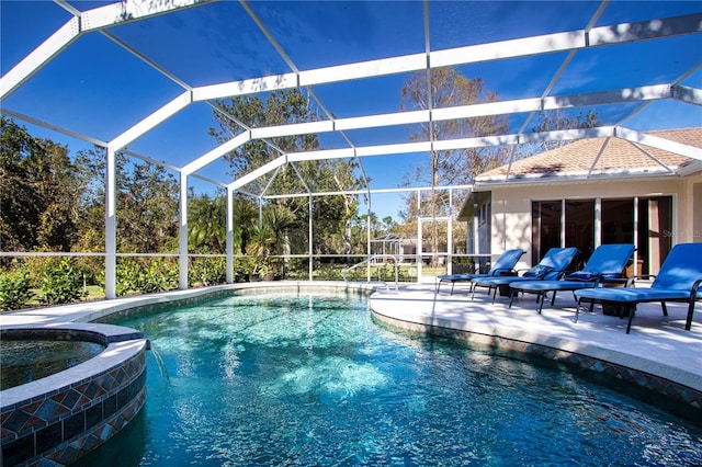 view of pool featuring a patio area, an in ground hot tub, and glass enclosure