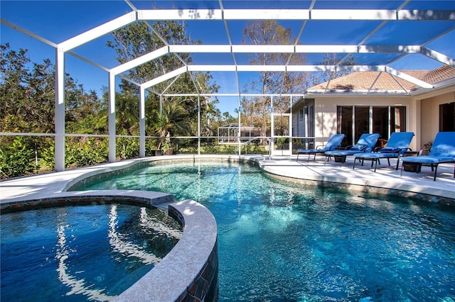 view of swimming pool featuring a lanai, an in ground hot tub, and a patio