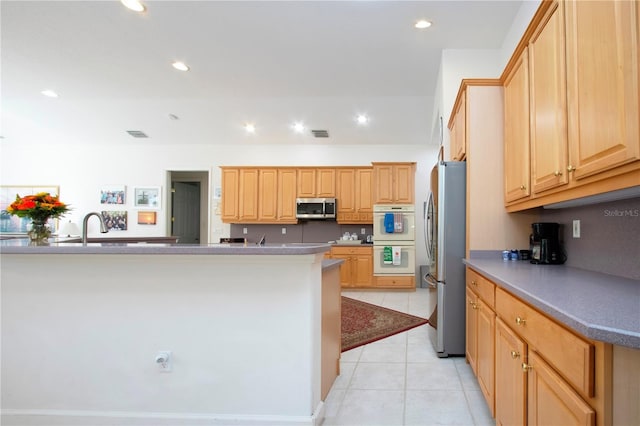 kitchen featuring light tile patterned floors, light brown cabinets, stainless steel appliances, and sink