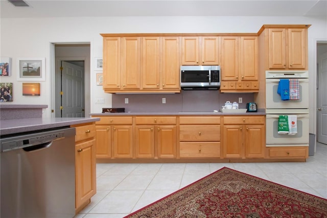 kitchen featuring light brown cabinets, light tile patterned floors, and appliances with stainless steel finishes