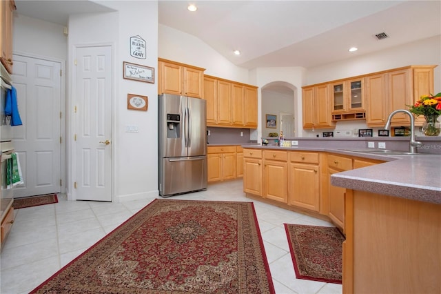 kitchen featuring light brown cabinets, sink, stainless steel fridge with ice dispenser, lofted ceiling, and light tile patterned floors