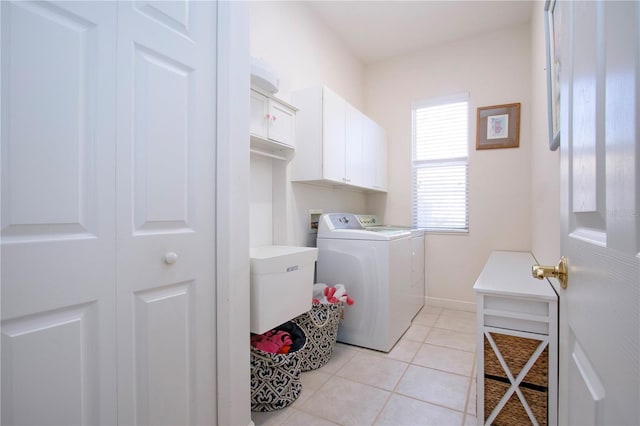 laundry room featuring cabinets, light tile patterned floors, and washer and clothes dryer