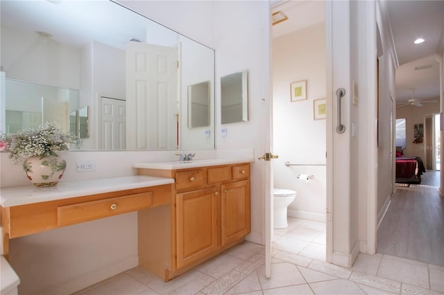 bathroom with tile patterned floors, vanity, ceiling fan, and toilet