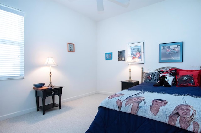 bedroom featuring multiple windows, ceiling fan, and light carpet