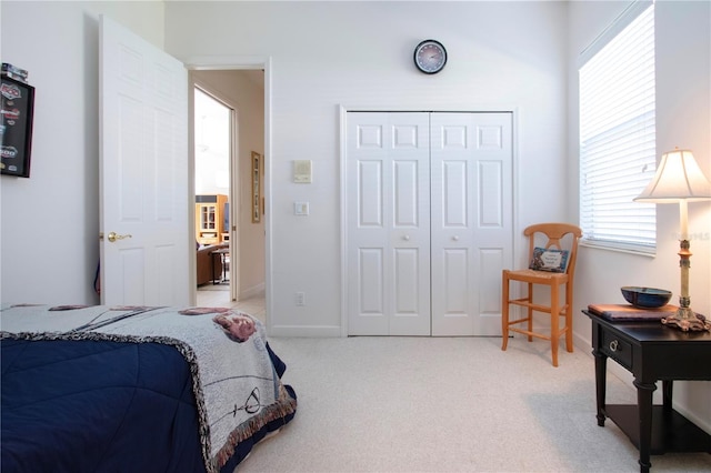 bedroom featuring light carpet and a closet