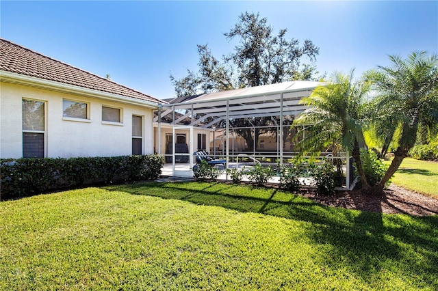 back of property featuring a lanai and a yard