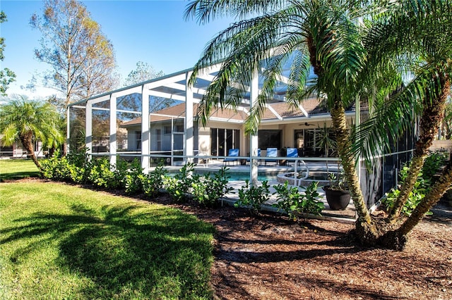 back of house with a lanai and ceiling fan