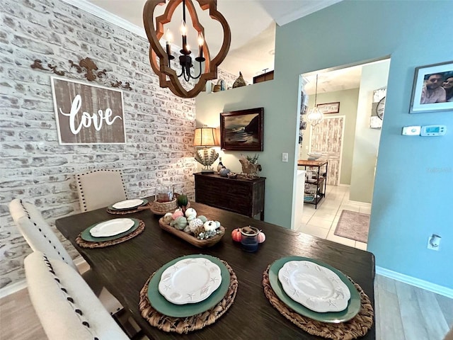 dining area with light tile patterned flooring, a chandelier, and brick wall