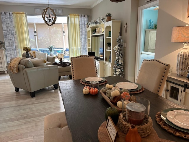 dining space featuring an inviting chandelier, light hardwood / wood-style flooring, and crown molding