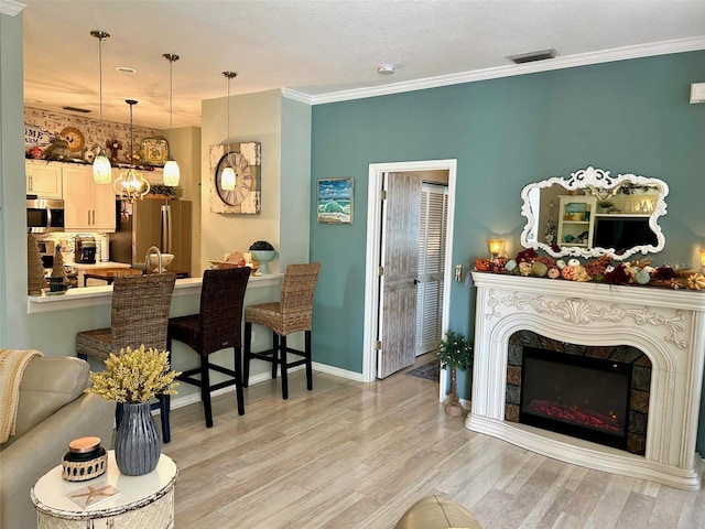 living room featuring crown molding and light hardwood / wood-style flooring