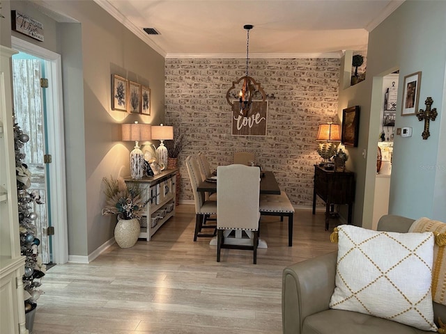 dining area with ornamental molding, brick wall, and light hardwood / wood-style flooring