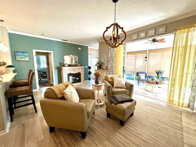 living room with ceiling fan with notable chandelier and crown molding